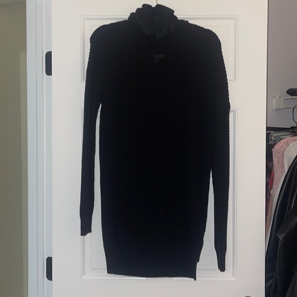 Long cable knit turtleneck sweater with side split.